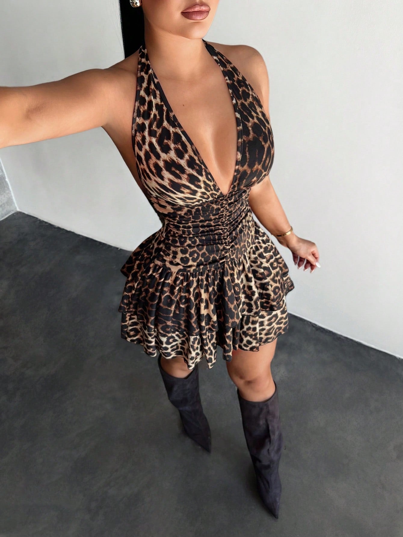 Women's sleeveless mini dress with leopard print, halter neckline, backless design, high waist, and tiered ruffle hem in a slim A-line fit.