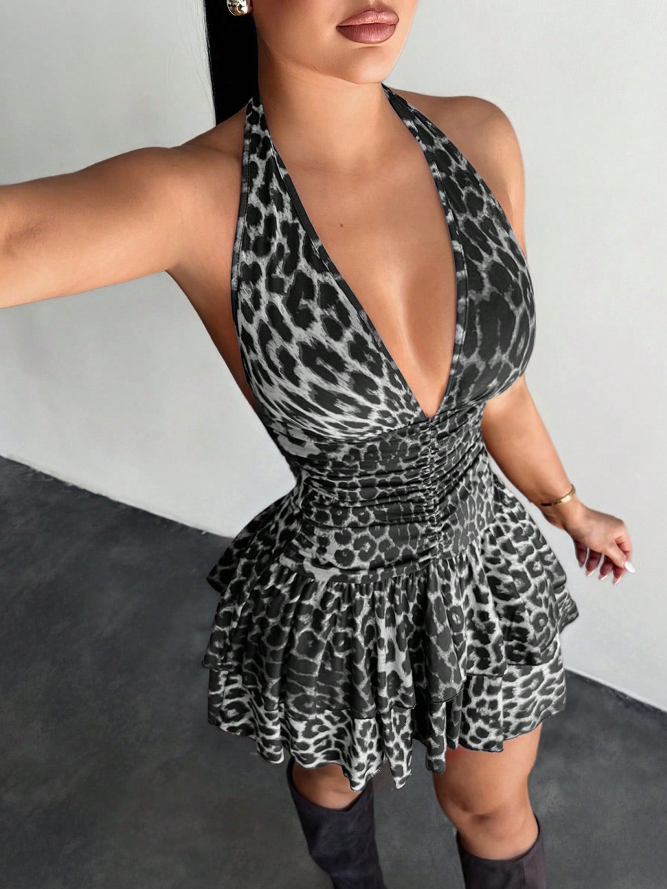 Women's sleeveless mini dress with leopard print, halter neckline, backless design, high waist, and tiered ruffle hem in a slim A-line fit.