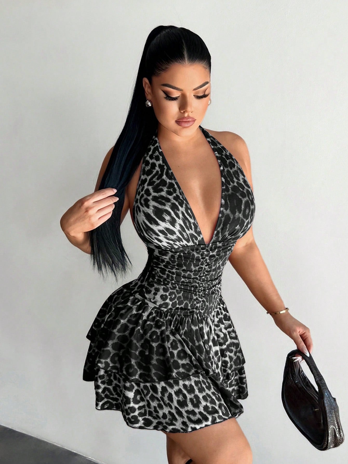Women's sleeveless mini dress with leopard print, halter neckline, backless design, high waist, and tiered ruffle hem in a slim A-line fit.