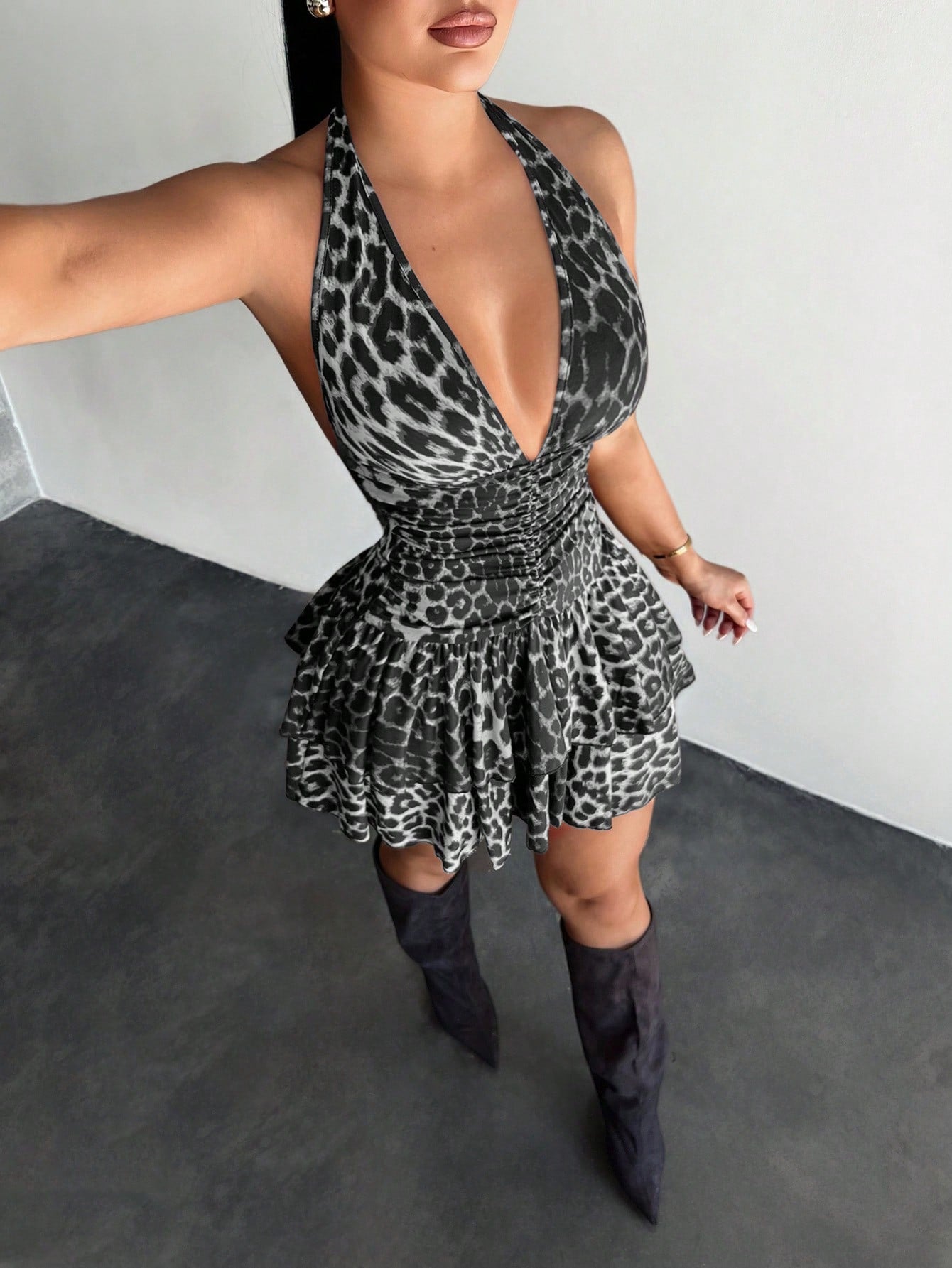 Women's sleeveless mini dress with leopard print, halter neckline, backless design, high waist, and tiered ruffle hem in a slim A-line fit.