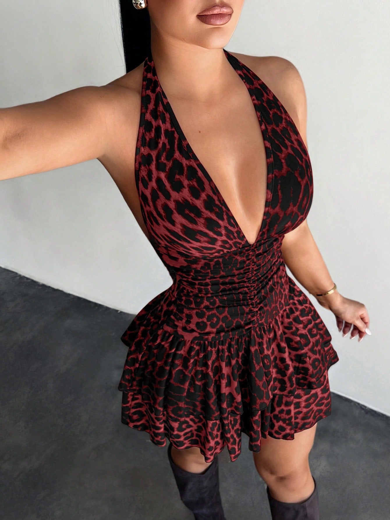 Women's sleeveless mini dress with leopard print, halter neckline, backless design, high waist, and tiered ruffle hem in a slim A-line fit.