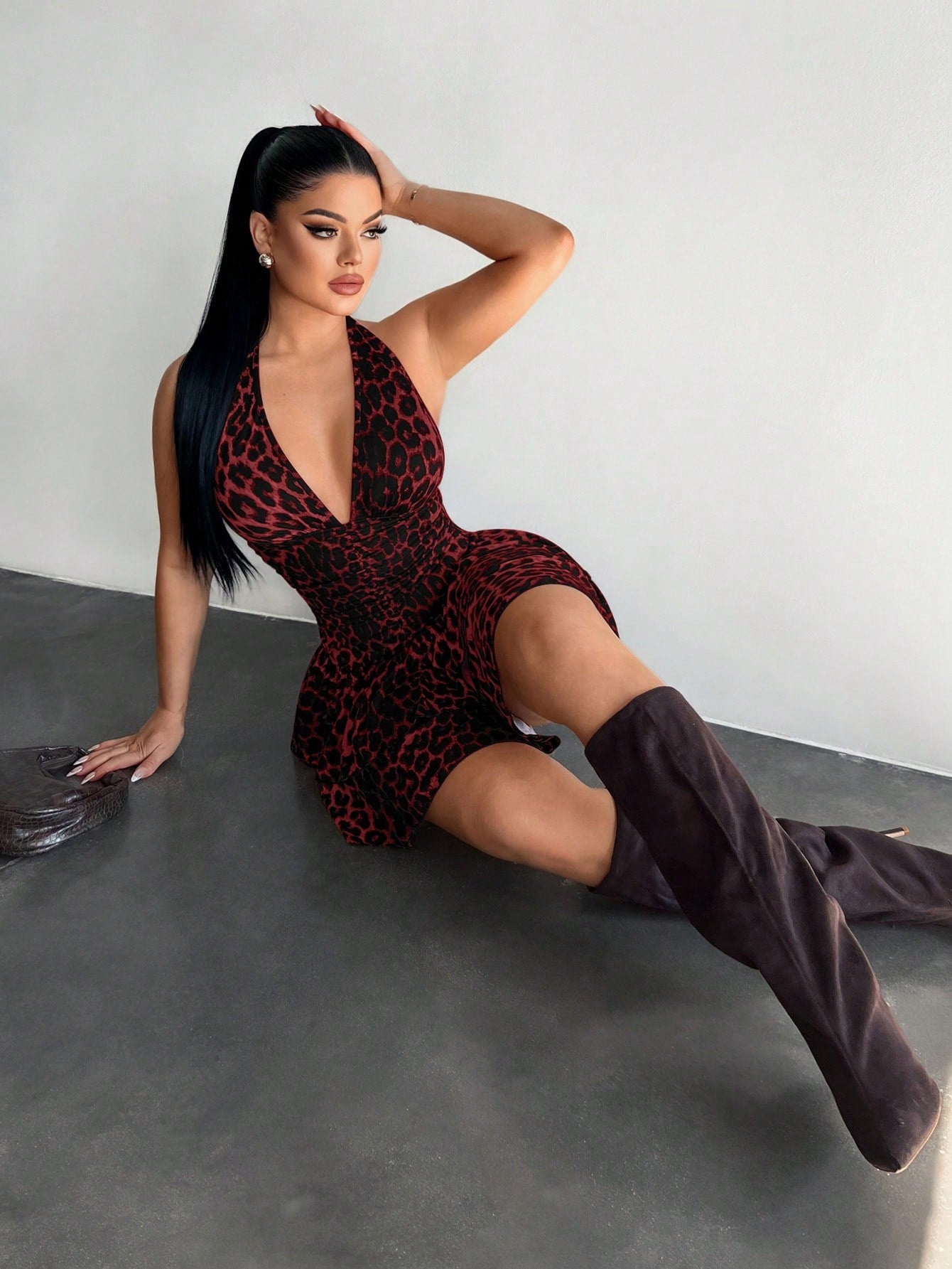 Women's sleeveless mini dress with leopard print, halter neckline, backless design, high waist, and tiered ruffle hem in a slim A-line fit.