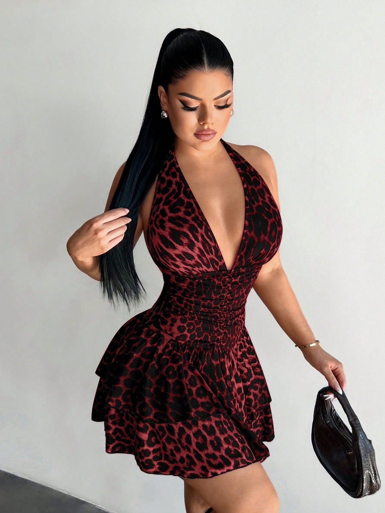 Women's sleeveless mini dress with leopard print, halter neckline, backless design, high waist, and tiered ruffle hem in a slim A-line fit.