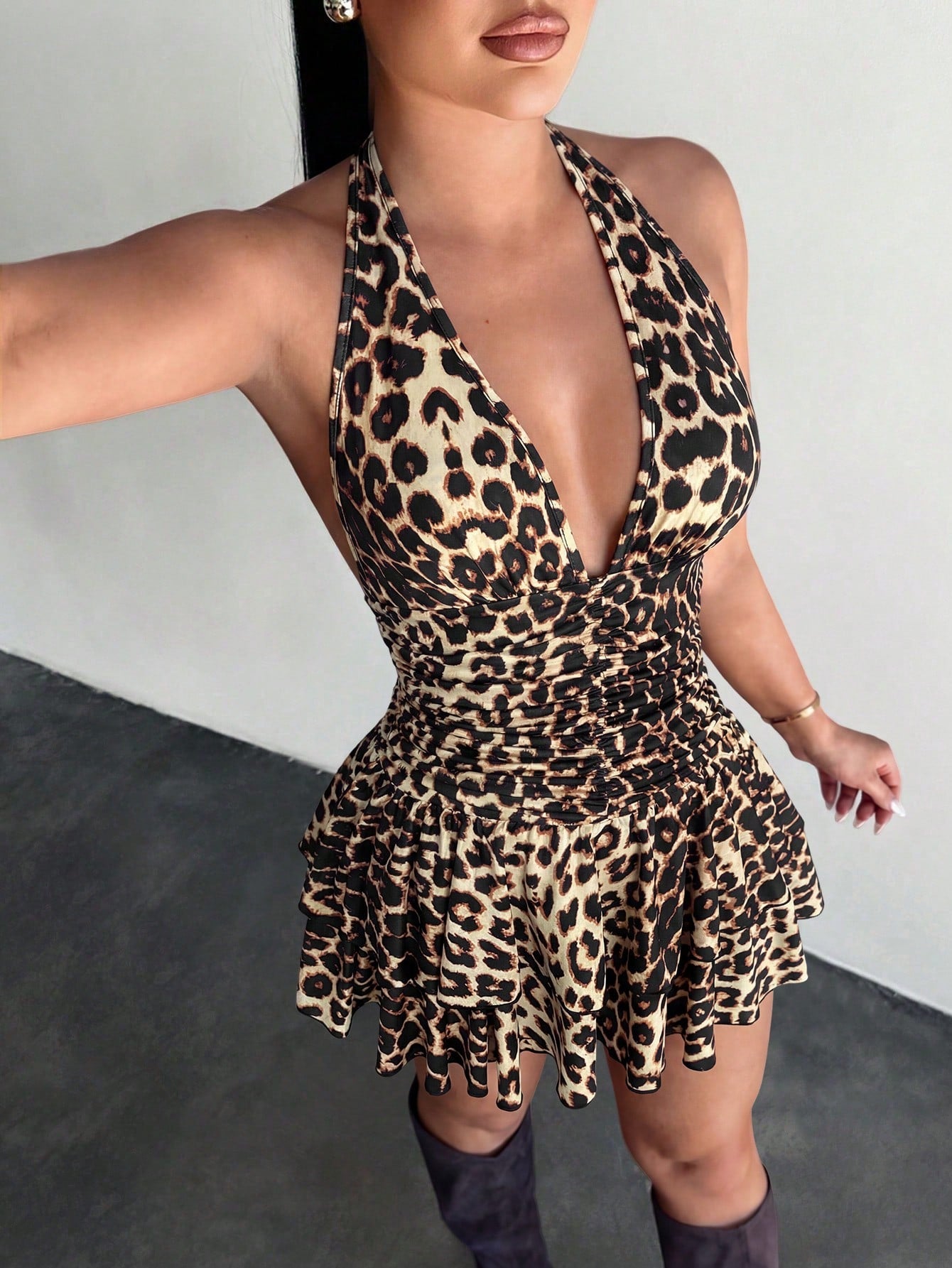 Women's sleeveless mini dress with leopard print, halter neckline, backless design, high waist, and tiered ruffle hem in a slim A-line fit.