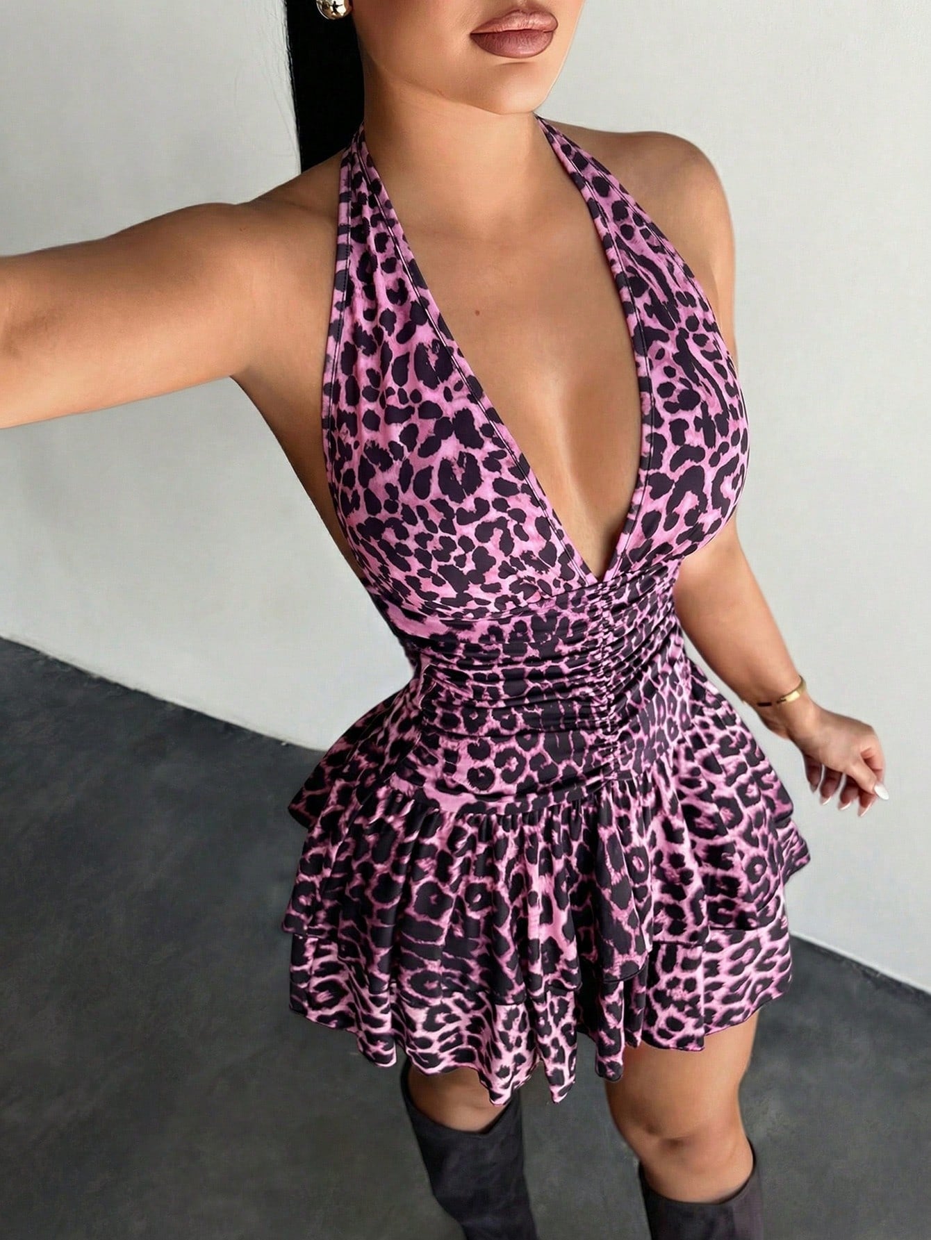 Women's sleeveless mini dress with leopard print, halter neckline, backless design, high waist, and tiered ruffle hem in a slim A-line fit.