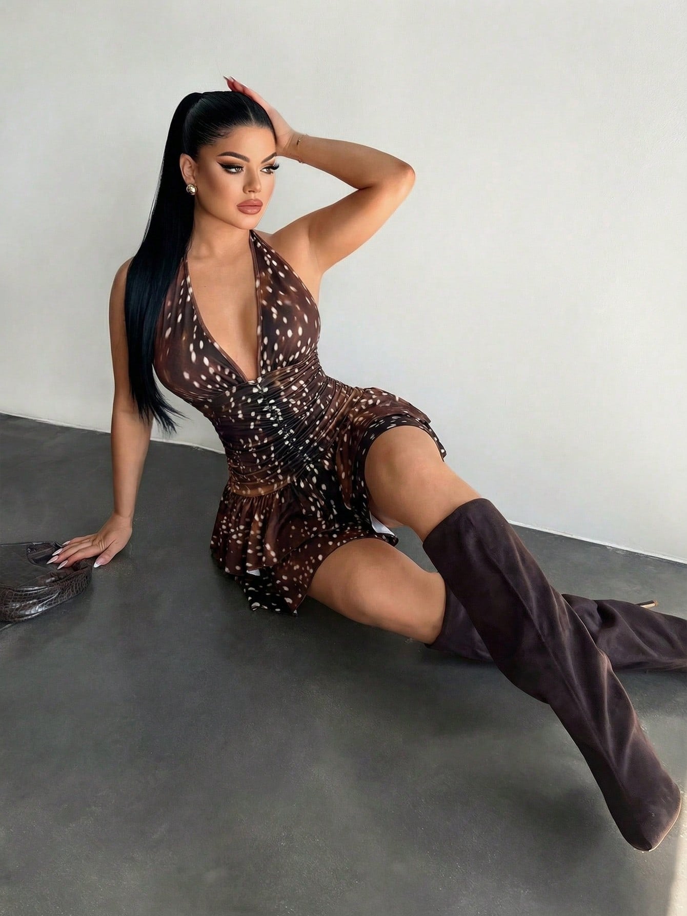 Women's sleeveless mini dress with leopard print, halter neckline, backless design, high waist, and tiered ruffle hem in a slim A-line fit.